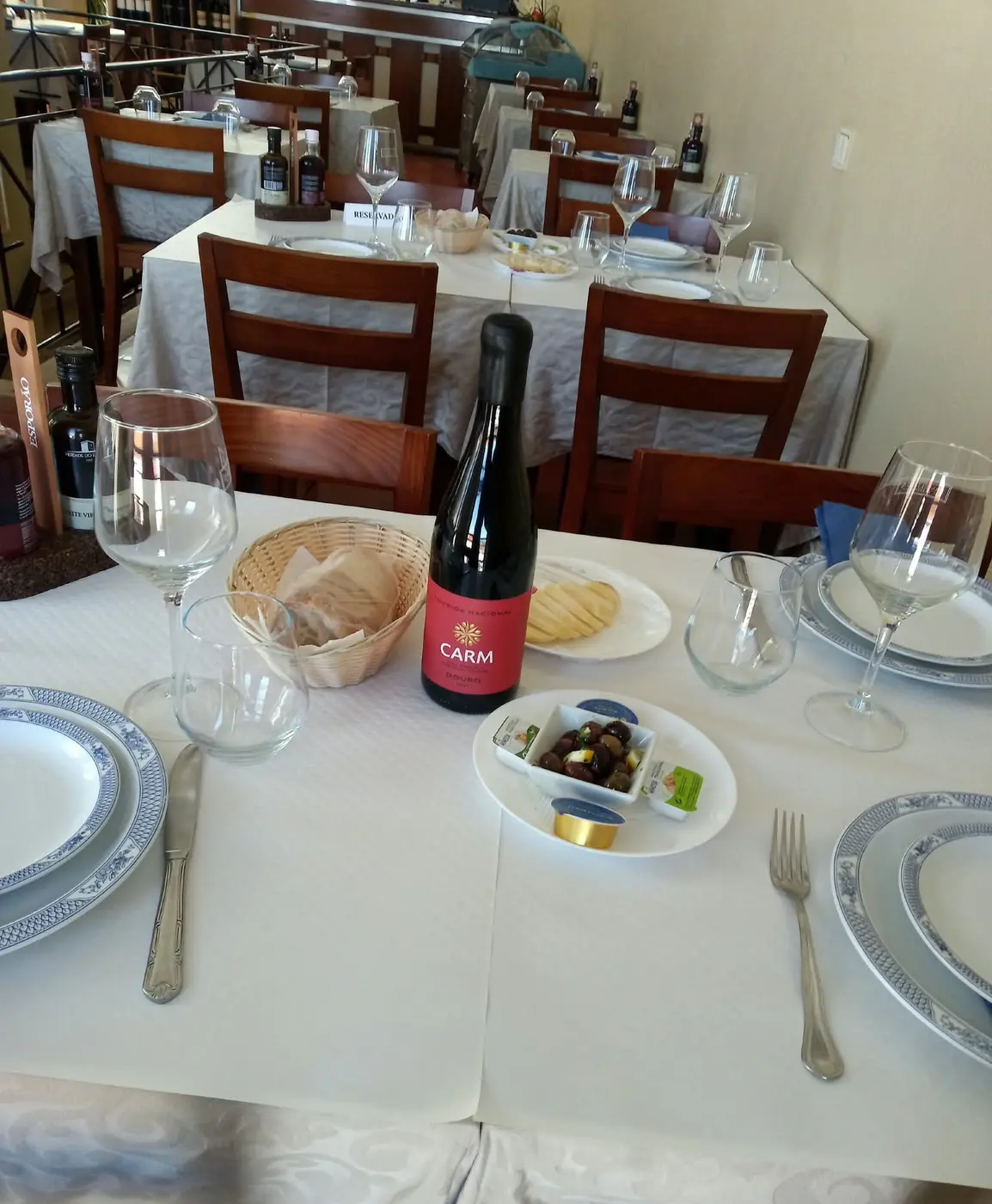 Mesa posta com pão, azeitonas e vinho