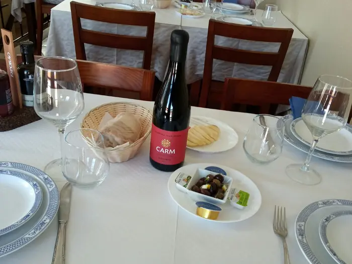 Mesa posta com pão, azeitonas e vinho